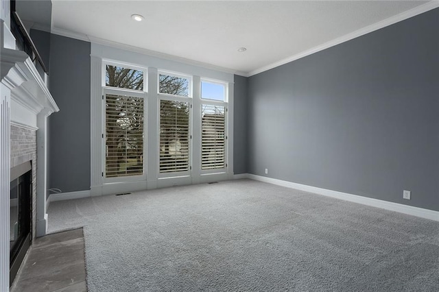 unfurnished living room with carpet, a fireplace, baseboards, and crown molding