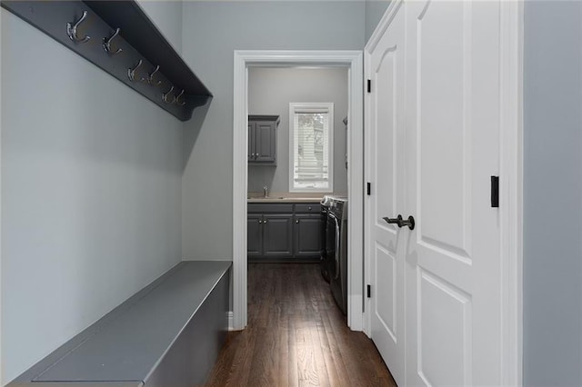 mudroom with dark wood finished floors and a sink