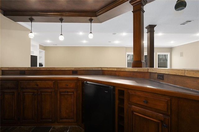 kitchen with fridge, decorative columns, visible vents, and crown molding