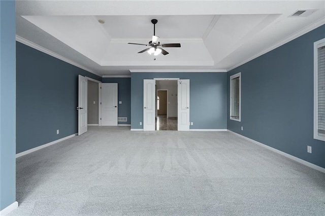 unfurnished bedroom featuring ornamental molding, a raised ceiling, visible vents, and baseboards