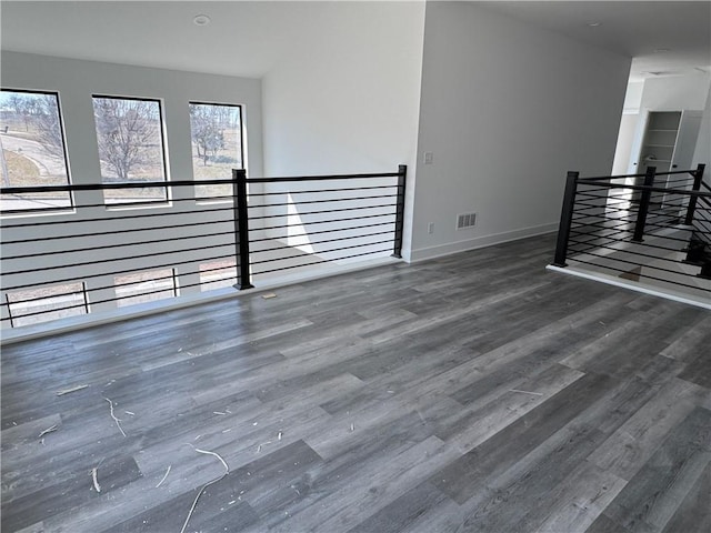 spare room with visible vents, baseboards, and wood finished floors