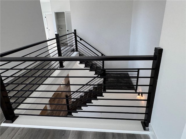 stairs with wood finished floors and baseboards