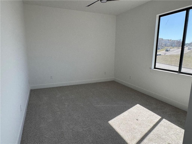 unfurnished room with carpet flooring, baseboards, and a ceiling fan