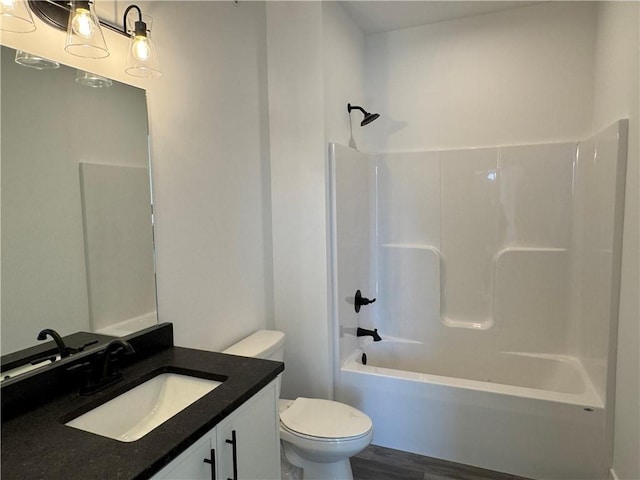 bathroom featuring shower / bathing tub combination, toilet, wood finished floors, and vanity