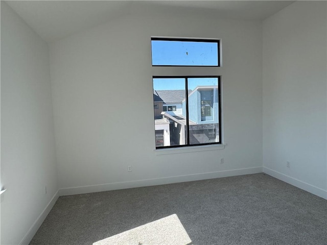 spare room featuring baseboards, carpet flooring, and vaulted ceiling