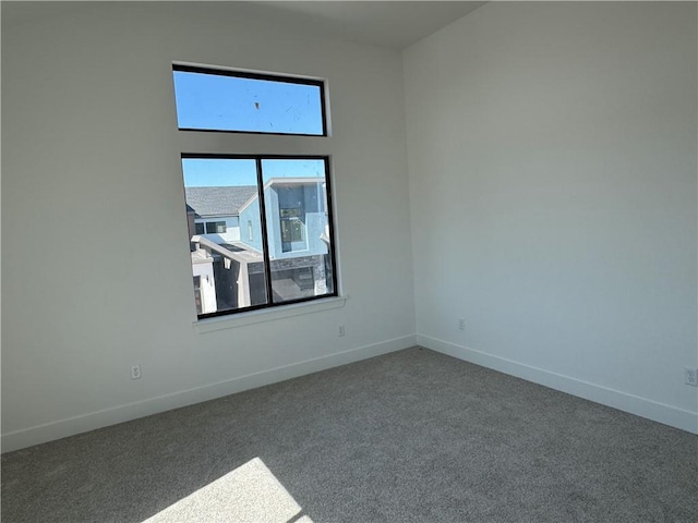 carpeted spare room featuring baseboards