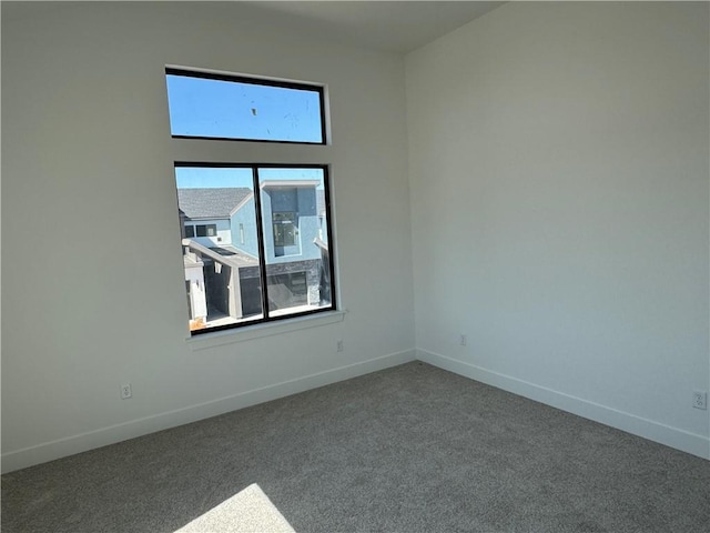 carpeted spare room featuring baseboards