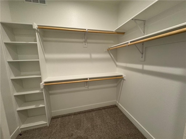 walk in closet with visible vents and dark colored carpet