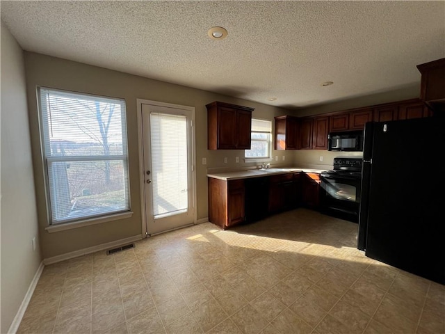 kitchen featuring black appliances and a textured ceiling