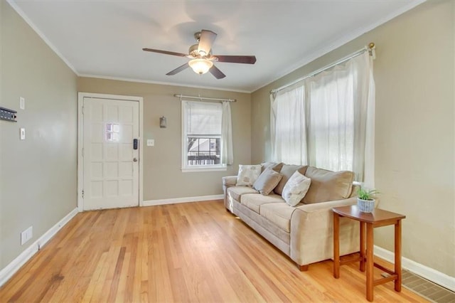 living room with crown molding, ceiling fan, and light hardwood / wood-style flooring