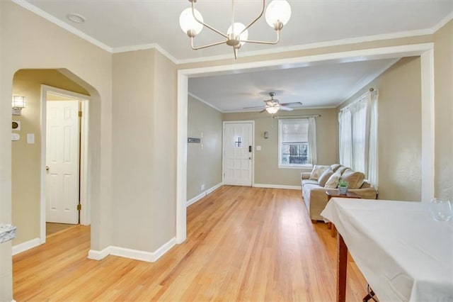 foyer with ornamental molding, wood-type flooring, and ceiling fan with notable chandelier