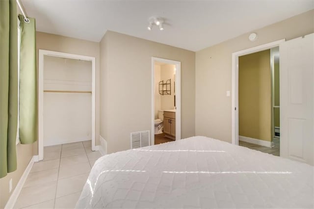 tiled bedroom featuring ensuite bath and a closet