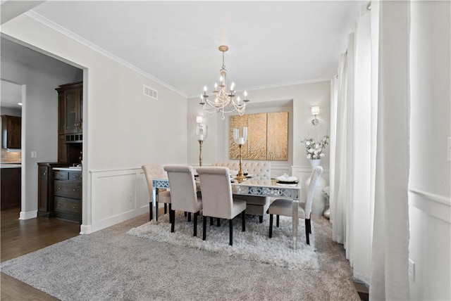 dining room with crown molding, a chandelier, and hardwood / wood-style floors