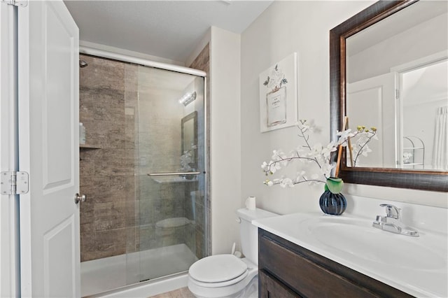 bathroom featuring vanity, toilet, and an enclosed shower