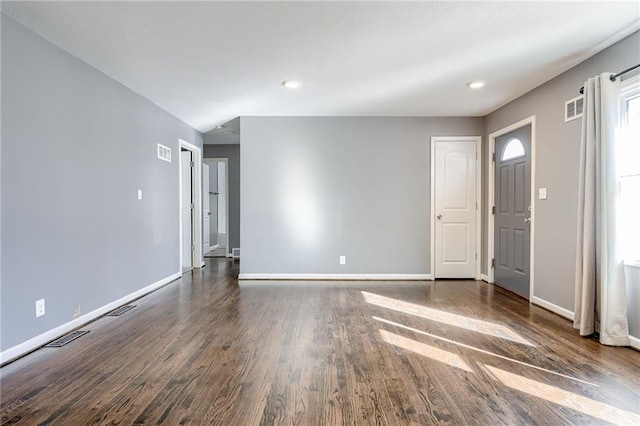 unfurnished room with visible vents, baseboards, and wood finished floors