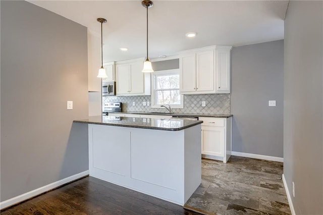 kitchen with a peninsula, white cabinetry, appliances with stainless steel finishes, and decorative backsplash