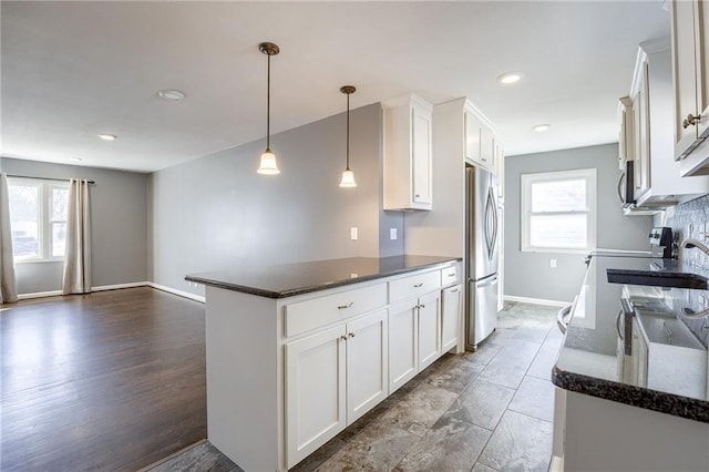 kitchen featuring appliances with stainless steel finishes, a wealth of natural light, and white cabinets