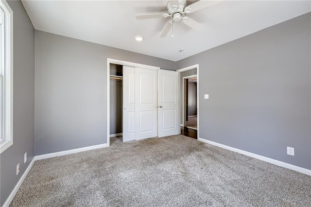 unfurnished bedroom with carpet, a closet, ceiling fan, and baseboards