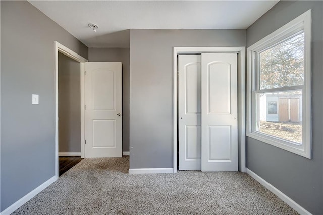 unfurnished bedroom featuring a closet, carpet, and baseboards