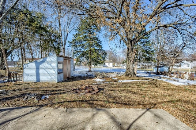 view of yard featuring an outbuilding, fence, and a shed