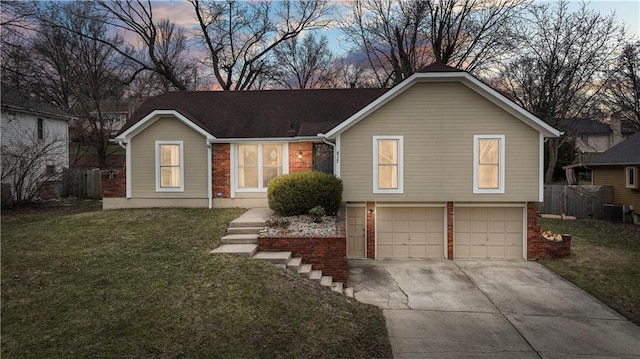 view of front facade featuring brick siding, an attached garage, central AC unit, a front yard, and driveway