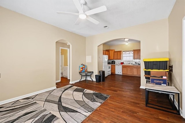 living room with dark hardwood / wood-style floors, sink, and ceiling fan