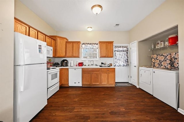 kitchen with white appliances, dark hardwood / wood-style floors, decorative backsplash, and washing machine and clothes dryer