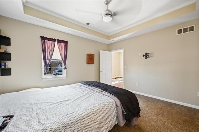 bedroom with a tray ceiling, carpet floors, ornamental molding, and ceiling fan