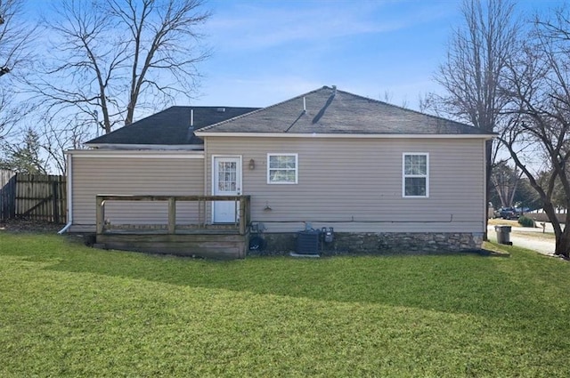 rear view of house with a yard and central AC