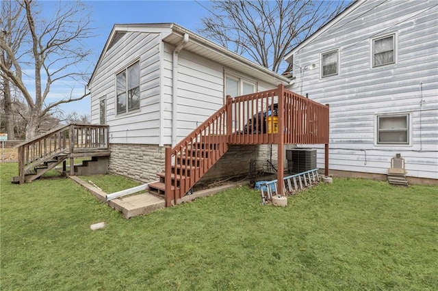 rear view of house with a deck, central AC unit, and a lawn