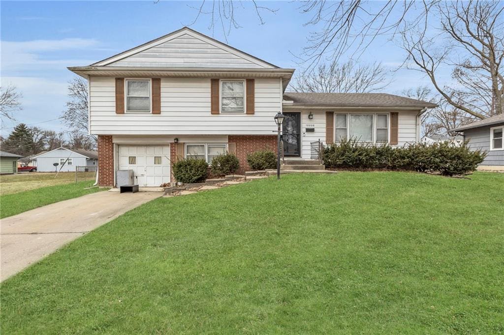 split level home with a garage and a front yard