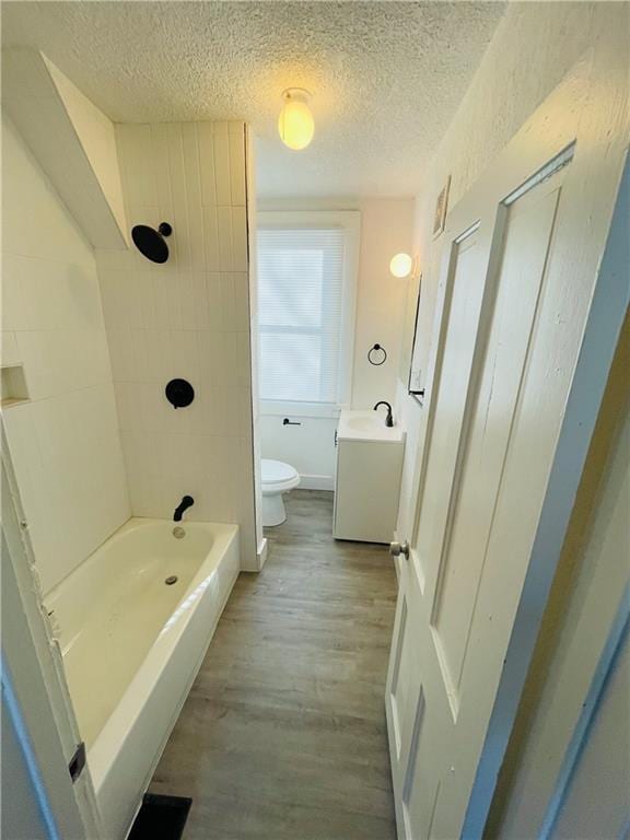 full bathroom featuring vanity, hardwood / wood-style floors, a textured ceiling, and toilet