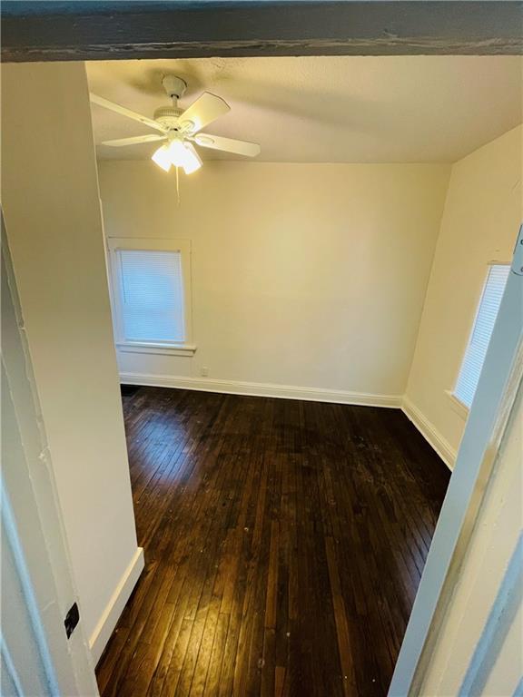 spare room featuring dark wood-type flooring and ceiling fan