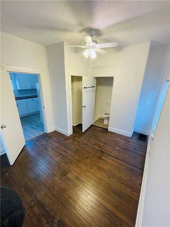 unfurnished bedroom with dark wood-type flooring, ceiling fan, and a textured ceiling