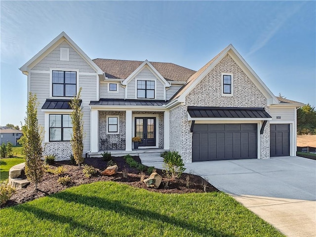 view of front of home with a garage, a front yard, and covered porch