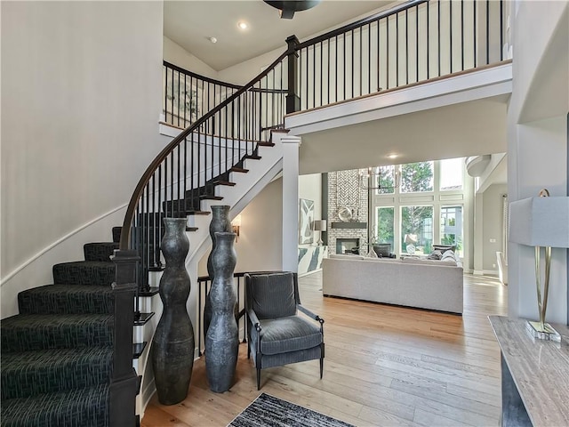 stairway featuring hardwood / wood-style floors and a towering ceiling