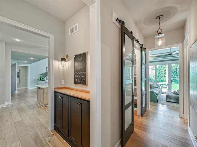 hallway featuring light hardwood / wood-style floors and a barn door