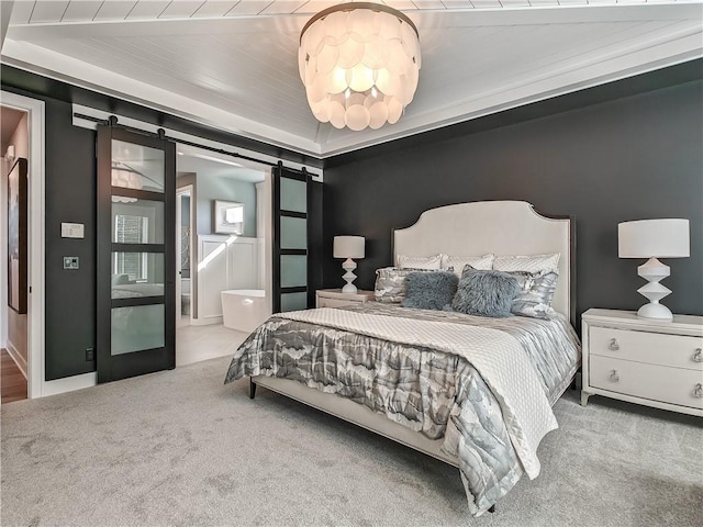 bedroom with a barn door and light colored carpet