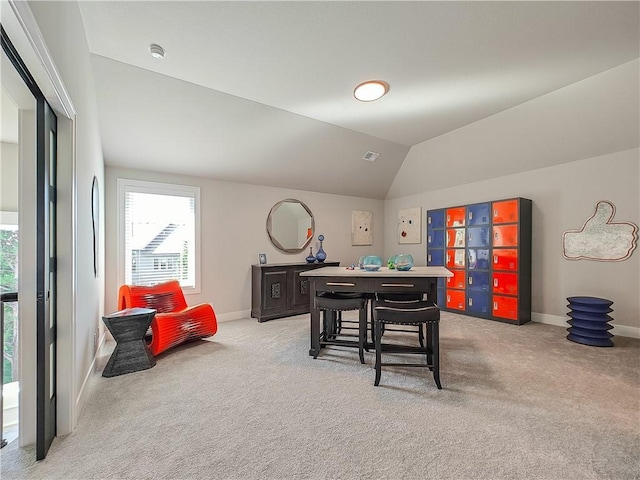 interior space with vaulted ceiling and light colored carpet