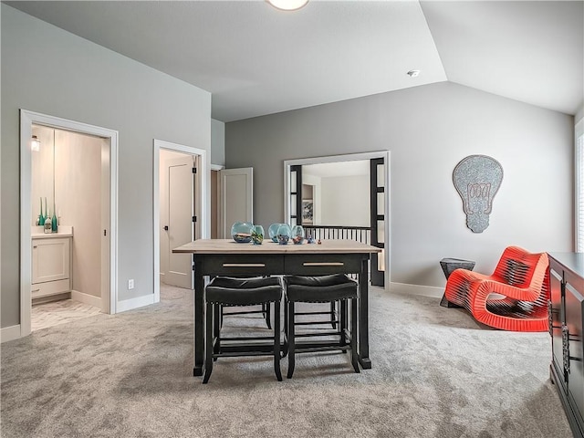 dining room featuring light carpet and lofted ceiling