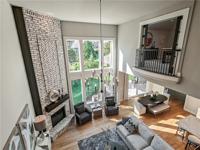 living room with a fireplace, light hardwood / wood-style floors, and a notable chandelier