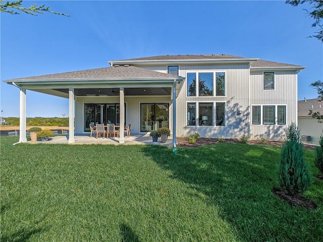 rear view of property with ceiling fan, a yard, and a patio