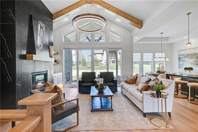 living area featuring wood finished floors, a chandelier, a fireplace, recessed lighting, and beamed ceiling