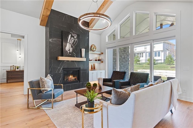 living area featuring a high end fireplace, wood finished floors, high vaulted ceiling, beamed ceiling, and built in features