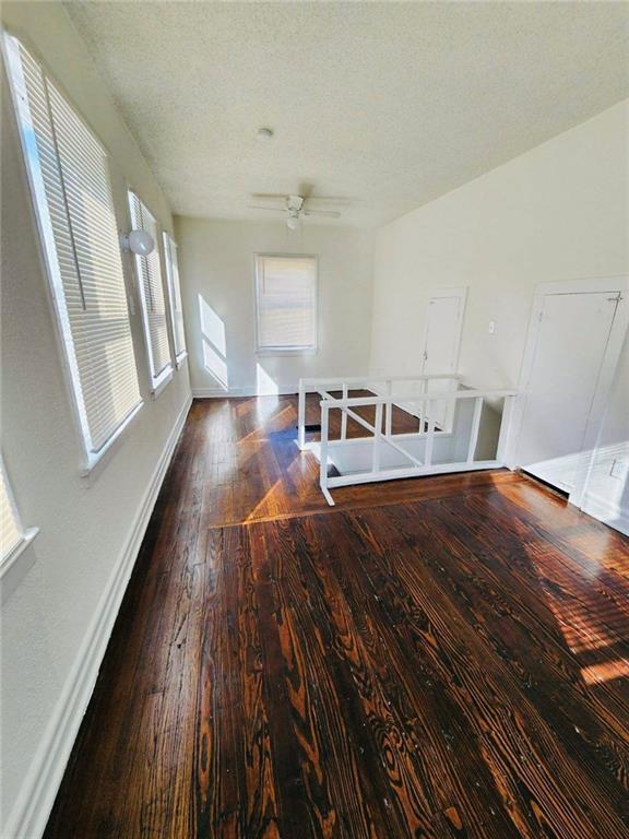 unfurnished room with dark hardwood / wood-style floors and a textured ceiling