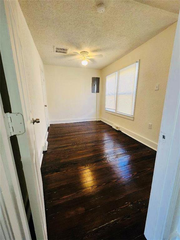 unfurnished room featuring ceiling fan, hardwood / wood-style floors, and a textured ceiling