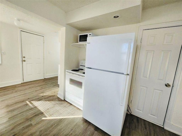 kitchen with hardwood / wood-style floors and white appliances