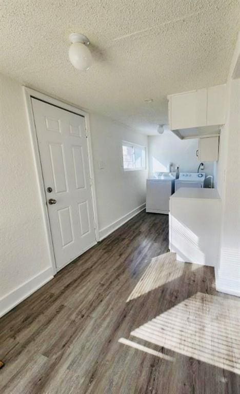 washroom featuring independent washer and dryer, dark hardwood / wood-style flooring, and a textured ceiling