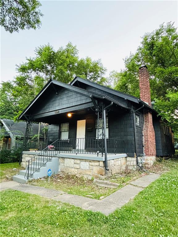 bungalow-style home with a front lawn and covered porch