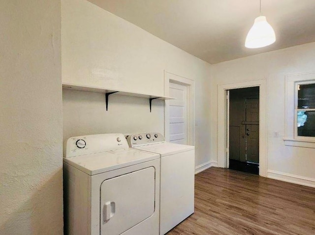 clothes washing area featuring hardwood / wood-style flooring and washer and dryer